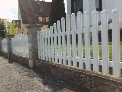 weißer Aluzaun mit Natursteinsäulen